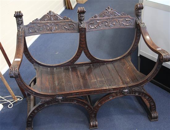 An Italian Renaissance design carved oak chair back settee, W.113cm